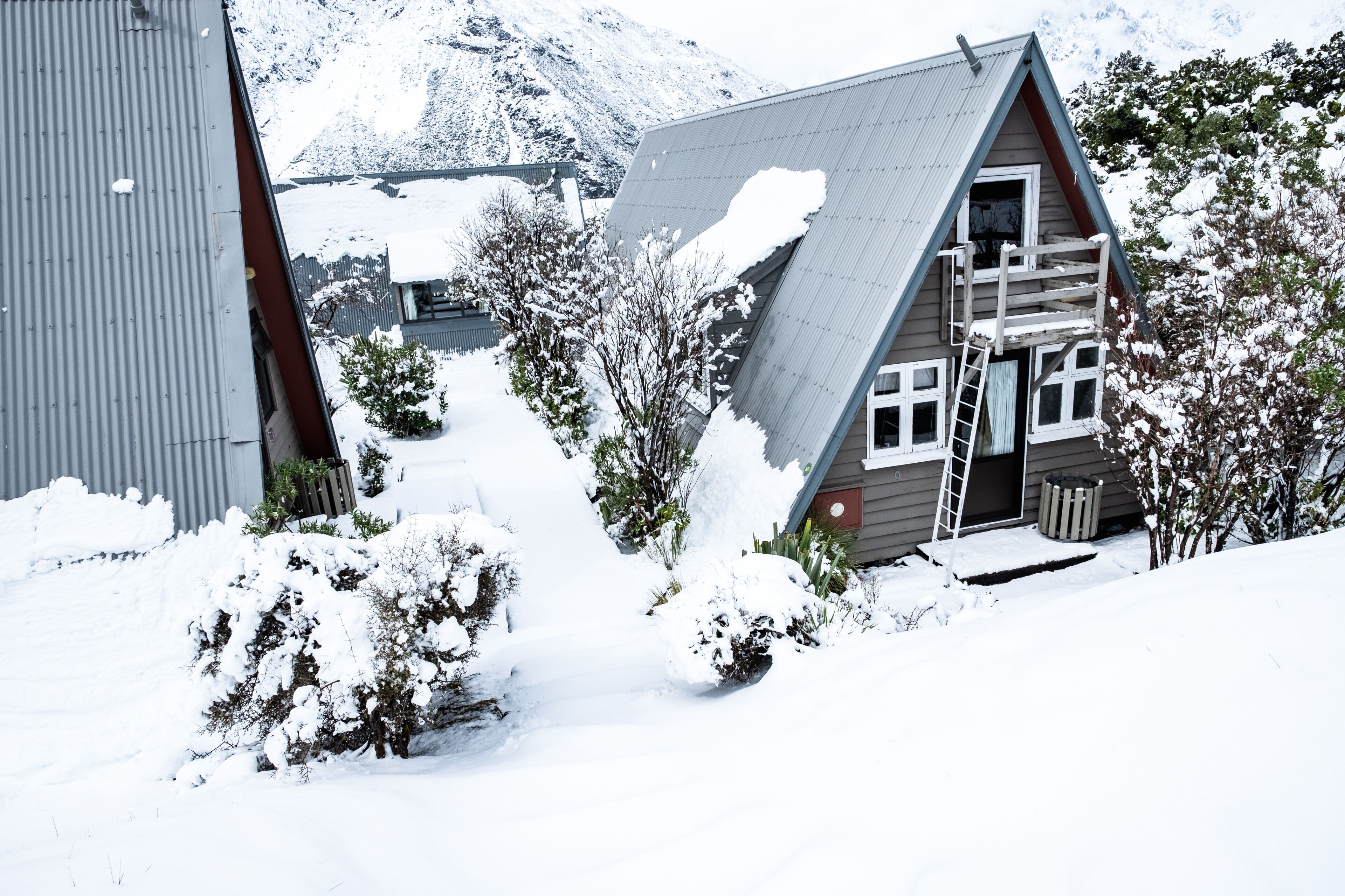 View of the houses in Mount Cook Village covered with white fresh snow in a snowy day.
