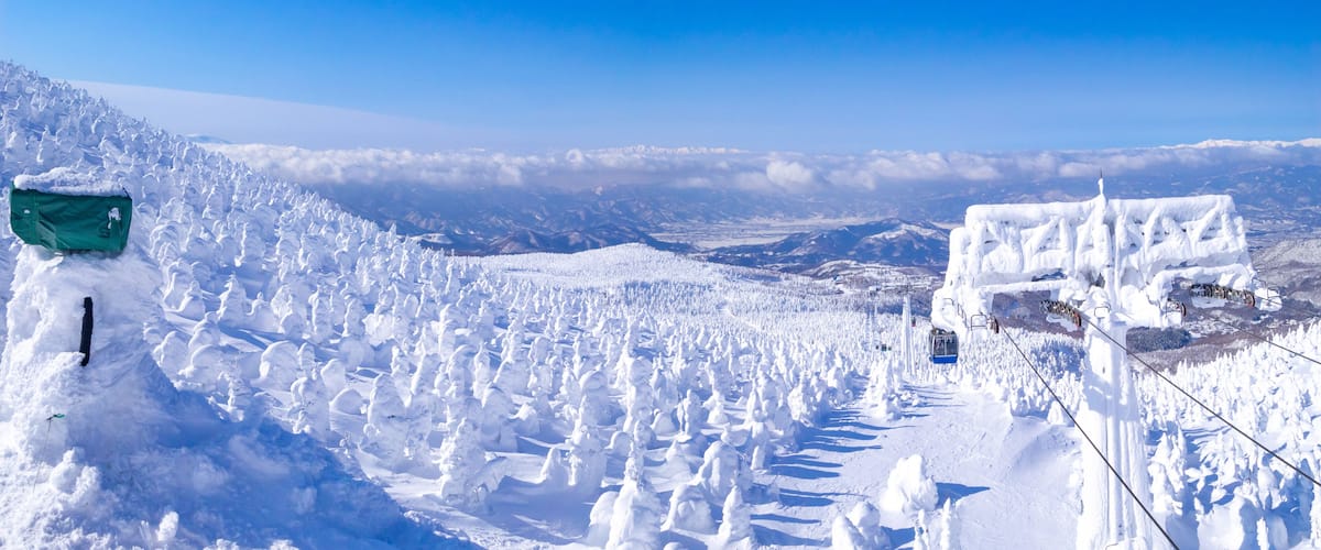 A snow-covered mountain landscape with a ski lift and a green sign.