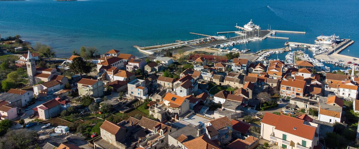 A coastal town with a marina, boats, and a church.