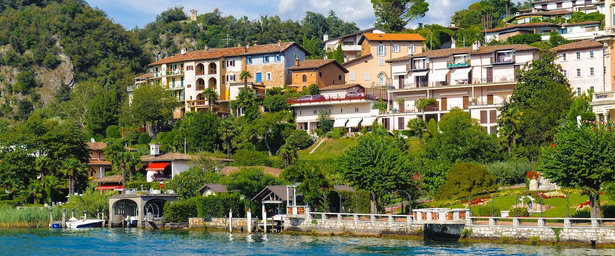 A hillside town with colorful buildings and a bridge over a body of water.