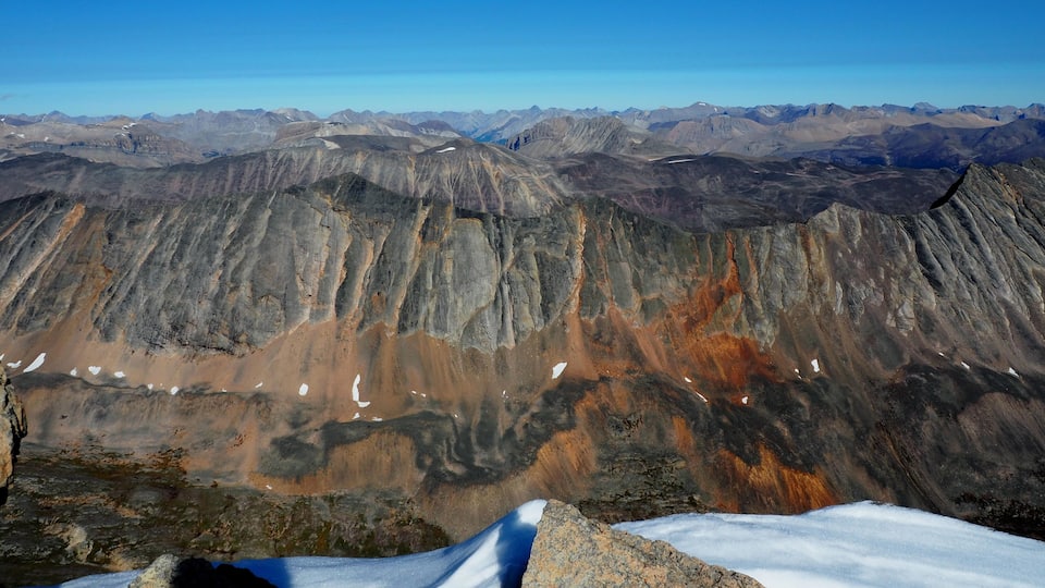 A mountain range with snow patches and rocky terrain.