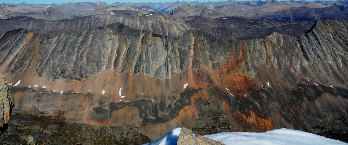 A mountain range with snow patches and rocky terrain.
