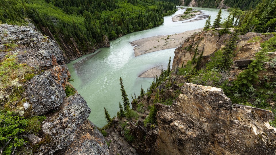 A river winding through a forested valley with rocky cliffs.