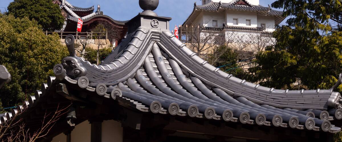 A traditional Japanese roof with curved eaves and a decorative finial.