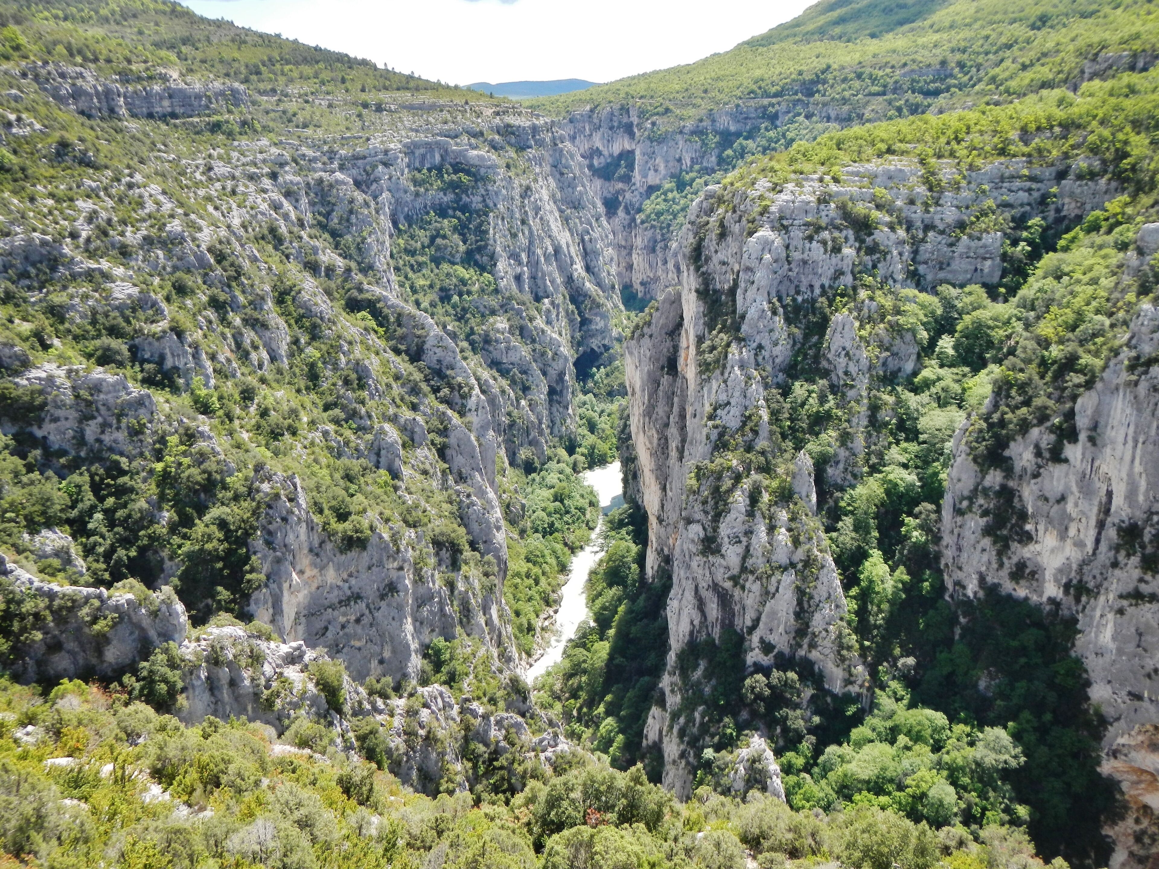 A canyon with steep cliffs and a river running through it.