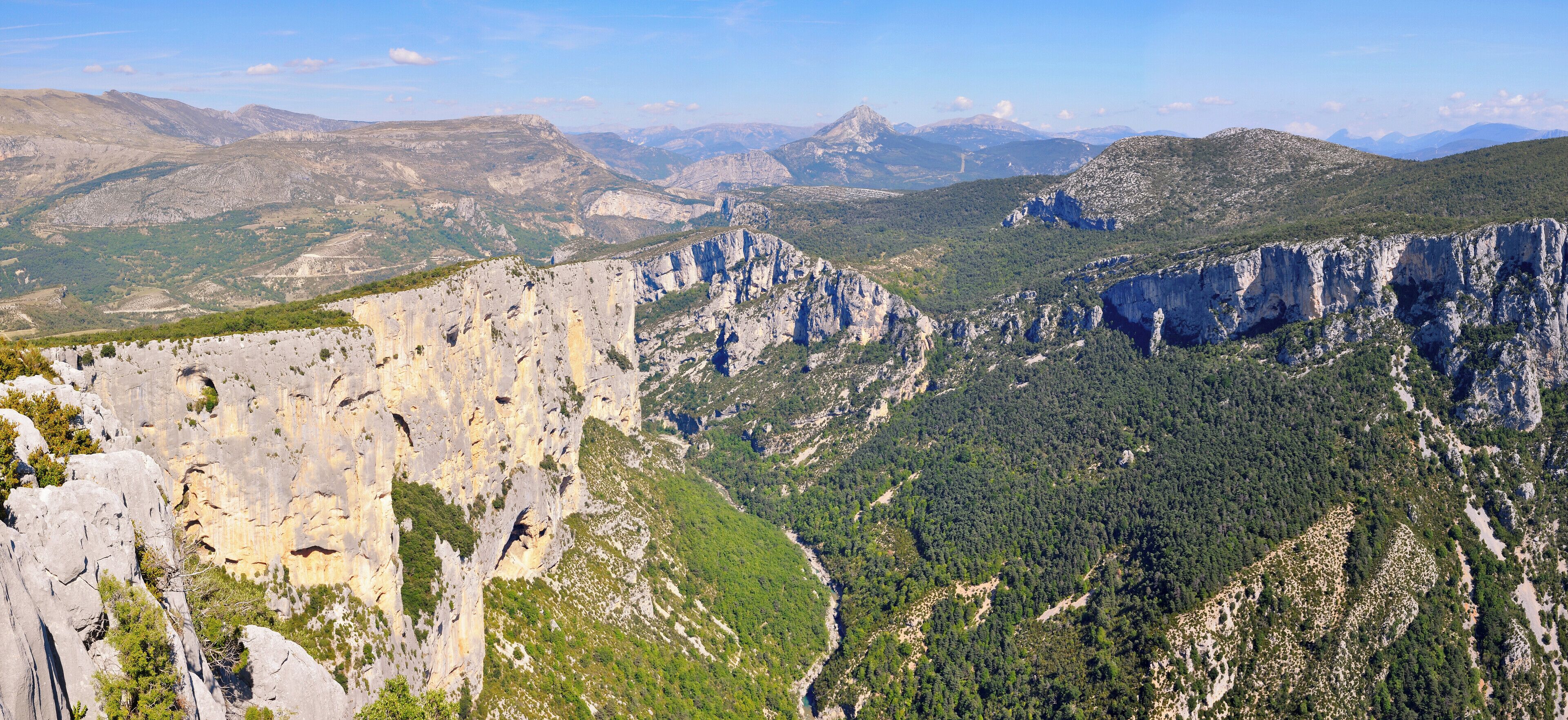 A mountainous landscape with rocky cliffs and dense forests.