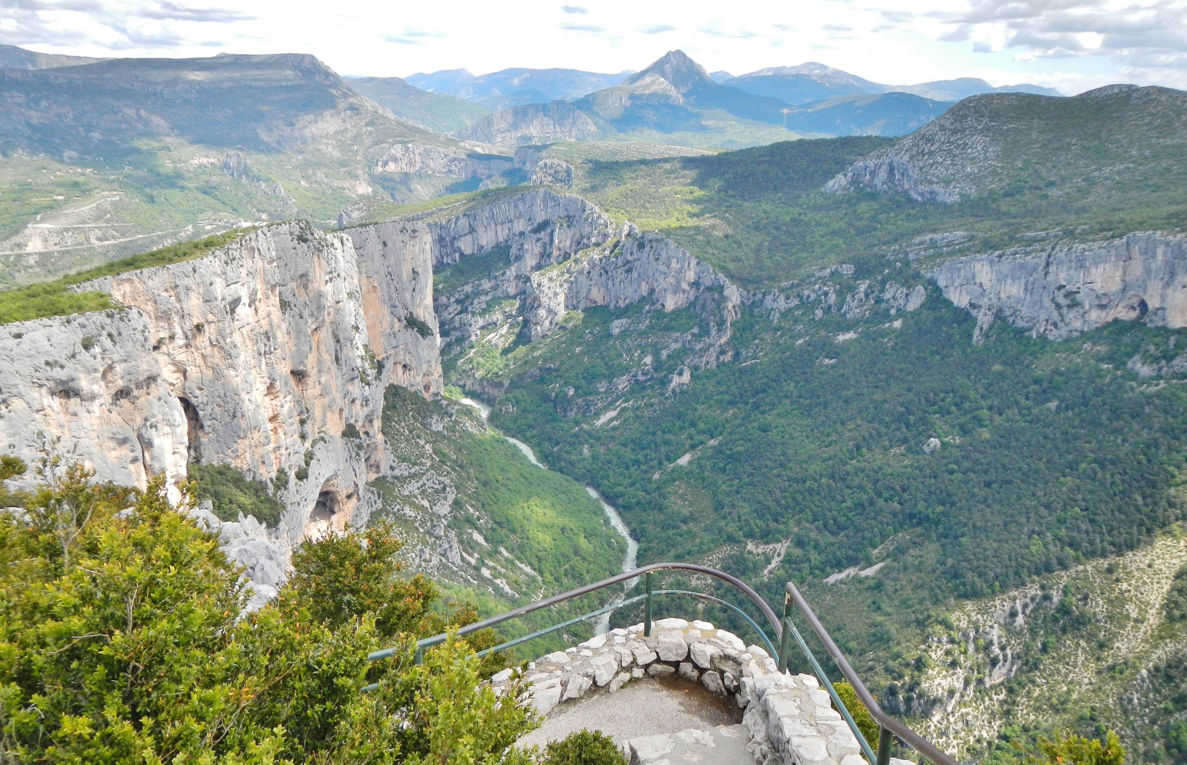 A mountainous landscape with a prominent rocky cliff and a winding river below.