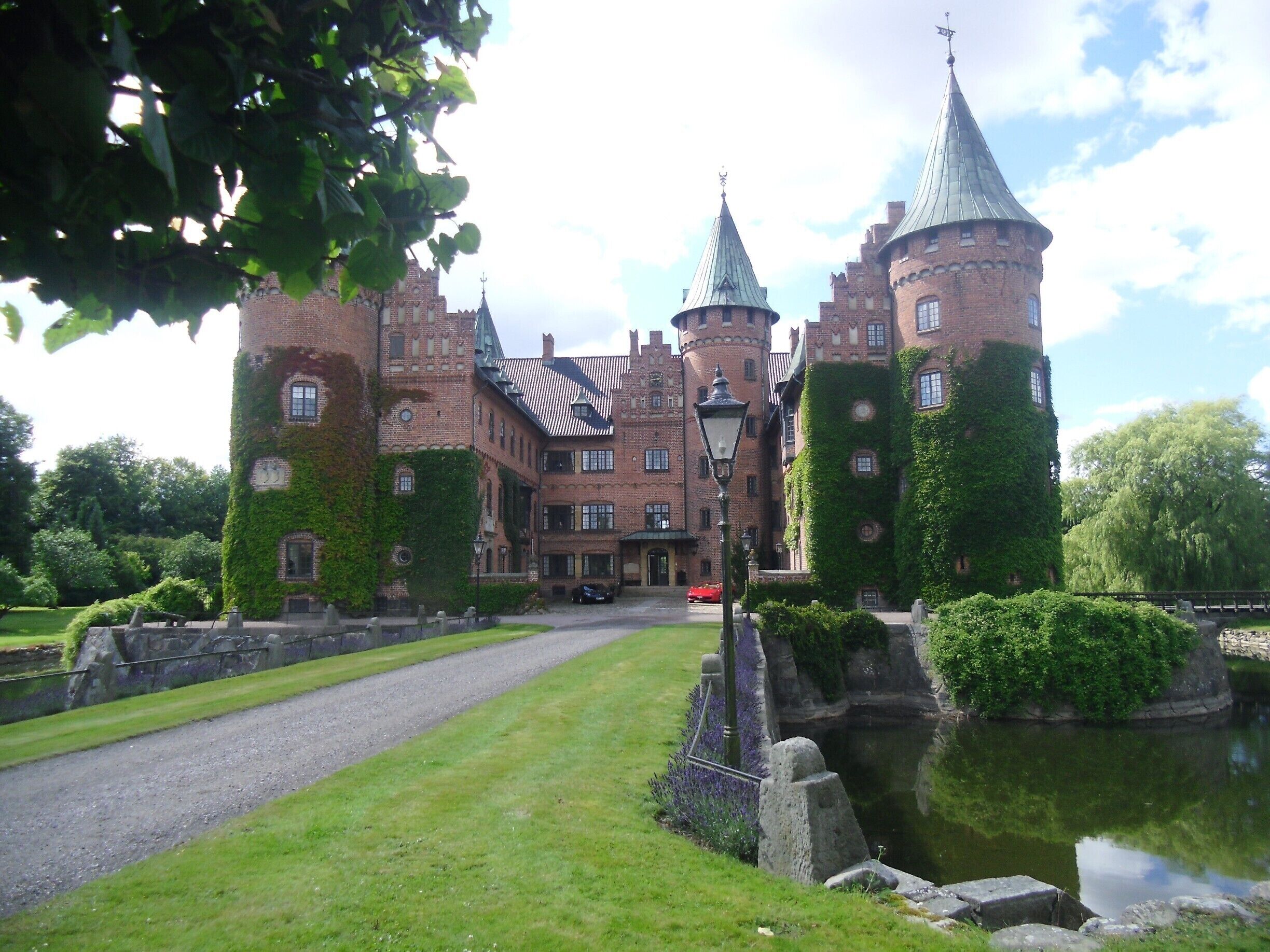 A historic castle with ivy-covered towers and a moat.