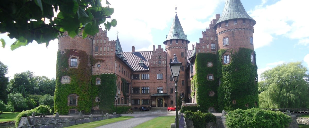 A historic castle with ivy-covered towers and a moat.