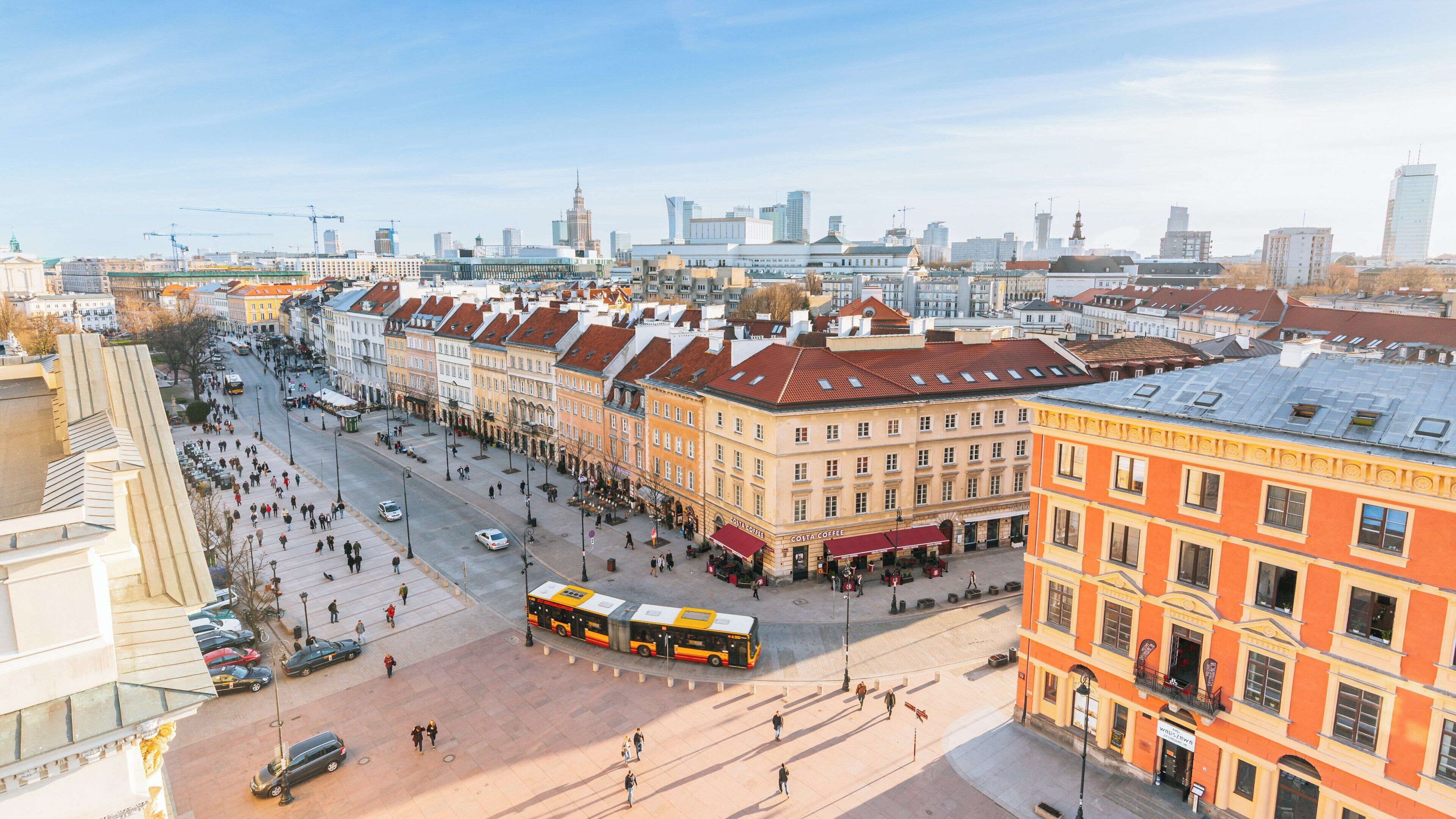 Exploring Nowy Swiat Street in Srodmiescie, Warsaw during a vibrant afternoon in spring, Poland with bustling crowds and iconic architecture