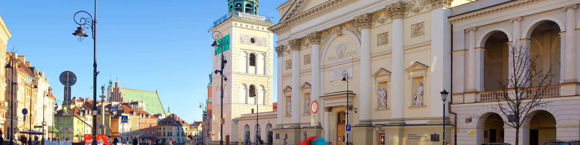 A historic building with classical architecture, a clock tower, and a clear blue sky.