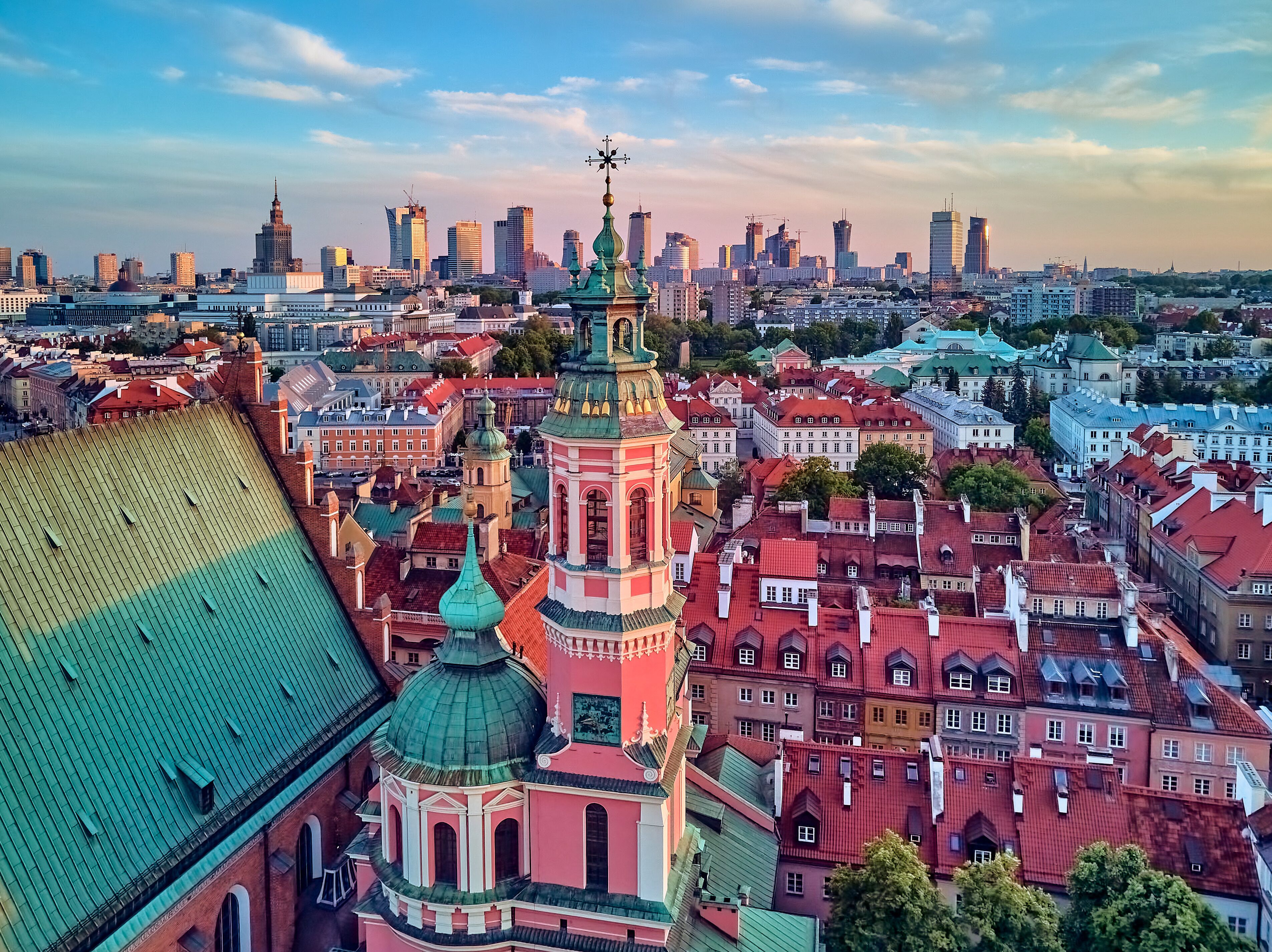 Beautiful panoramic aerial drone view on Warsaw Old town (POL: Stare Miasto) with modern skyscrapers on the horizon, Royal Castle, square and the Column of Sigismund III Vasa at sunset, Poland