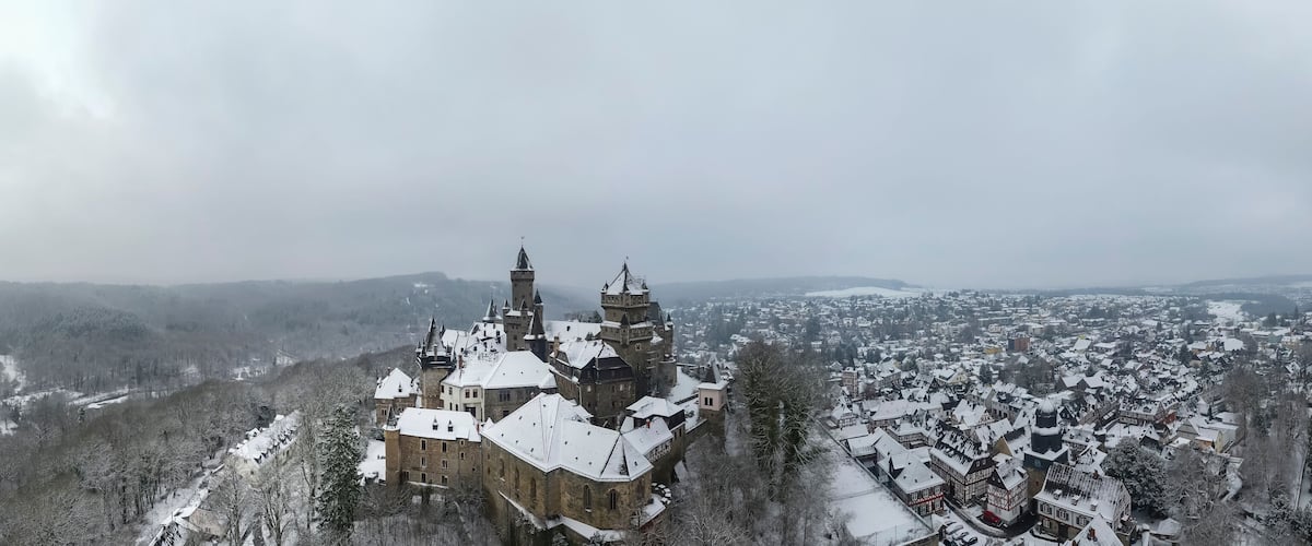 A snow-covered castle surrounded by a town.