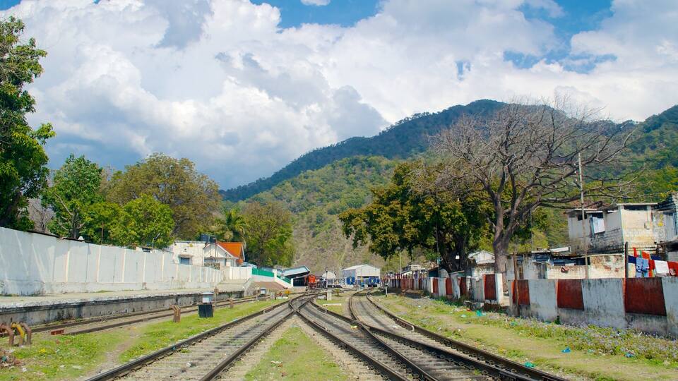 Railway tracks, a small building, and a mountainous landscape.