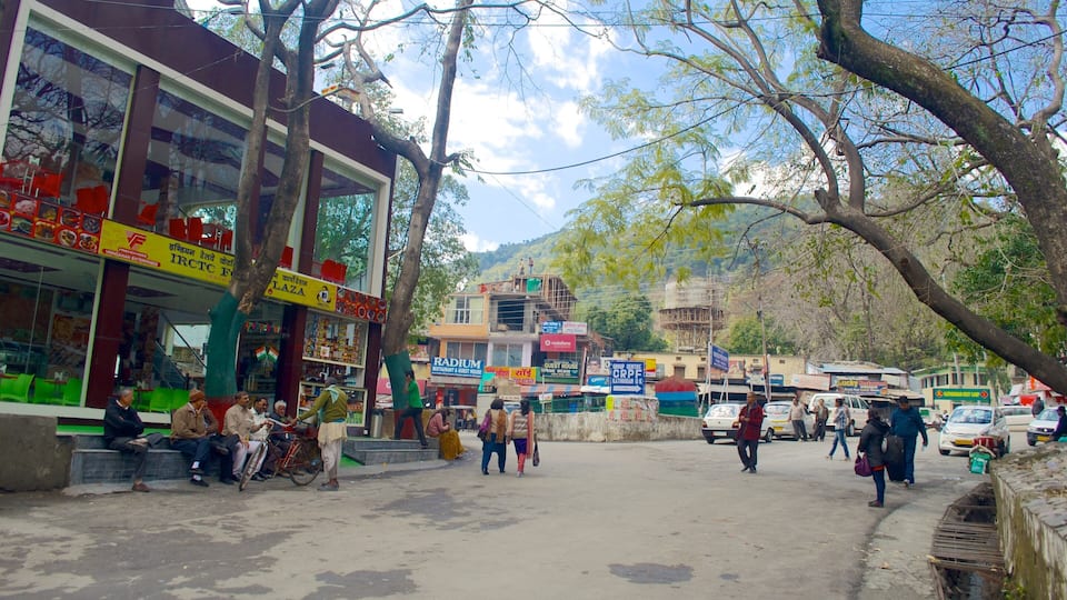 A street scene with shops, a guest house, and a mountainous backdrop.