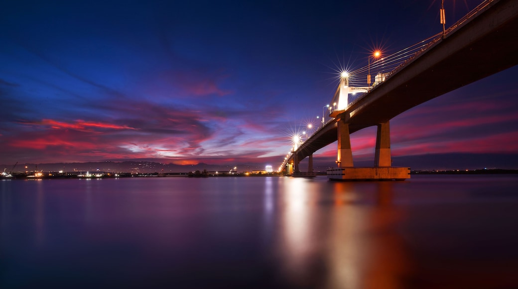 A bridge at twilight with a reflection on the water.
