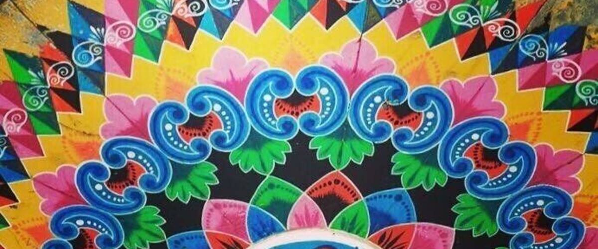A colorful, intricately designed ceiling with geometric patterns and floral motifs.