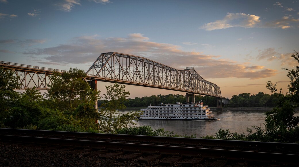 View of a serene sunset over the Mississippi River with a bridge and a boat, Chester, United States.