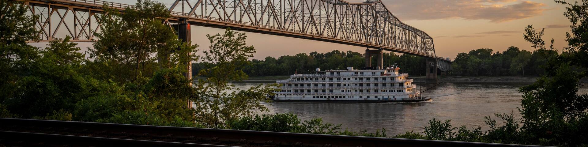 View of a serene sunset over the Mississippi River with a bridge and a boat, Chester, United States.