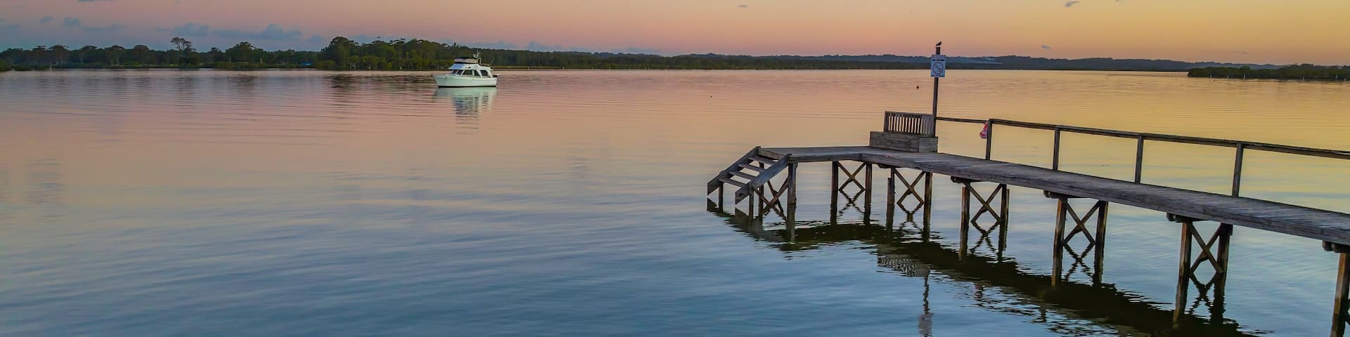 Sunset over the river with boat and wharf