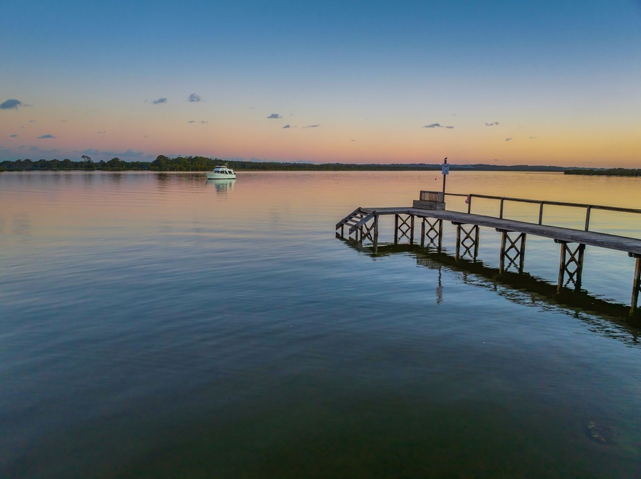 Sunset over the river with boat and wharf