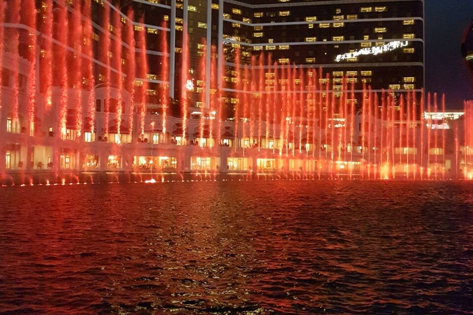 Een hotel met een fonteinverlichting 's nachts.