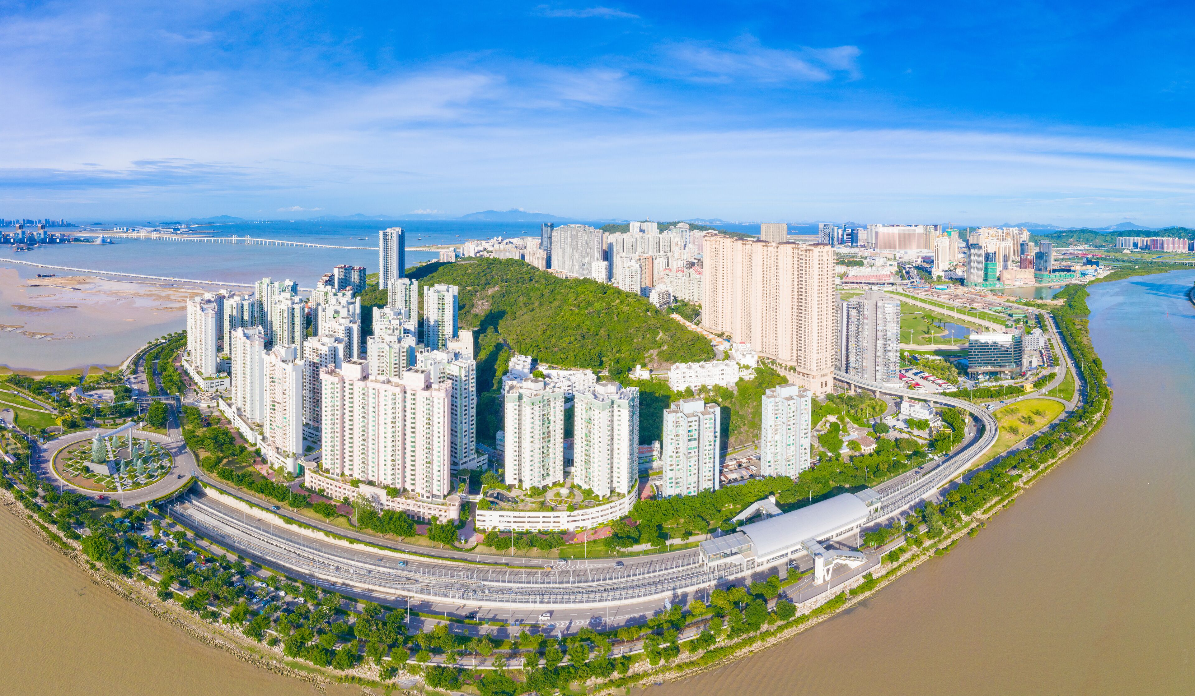 Zona residencial de rascacielos con un río y un puente al fondo.
