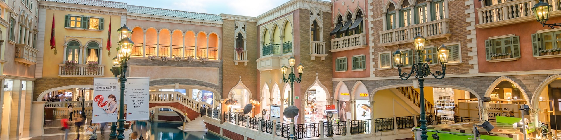 A Venetian-style indoor canal with gondolas, ornate buildings, and a shopping area.
