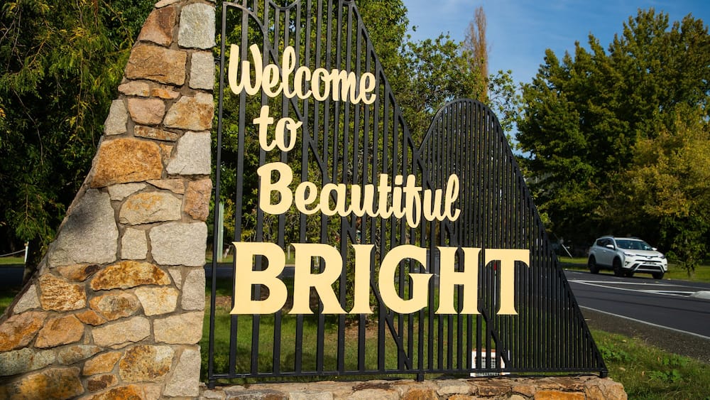 Un mur de pierre avec une porte en métal et une pancarte sur laquelle on peut lire : « Bienvenue à la magnifique ville de BRIGHT. »