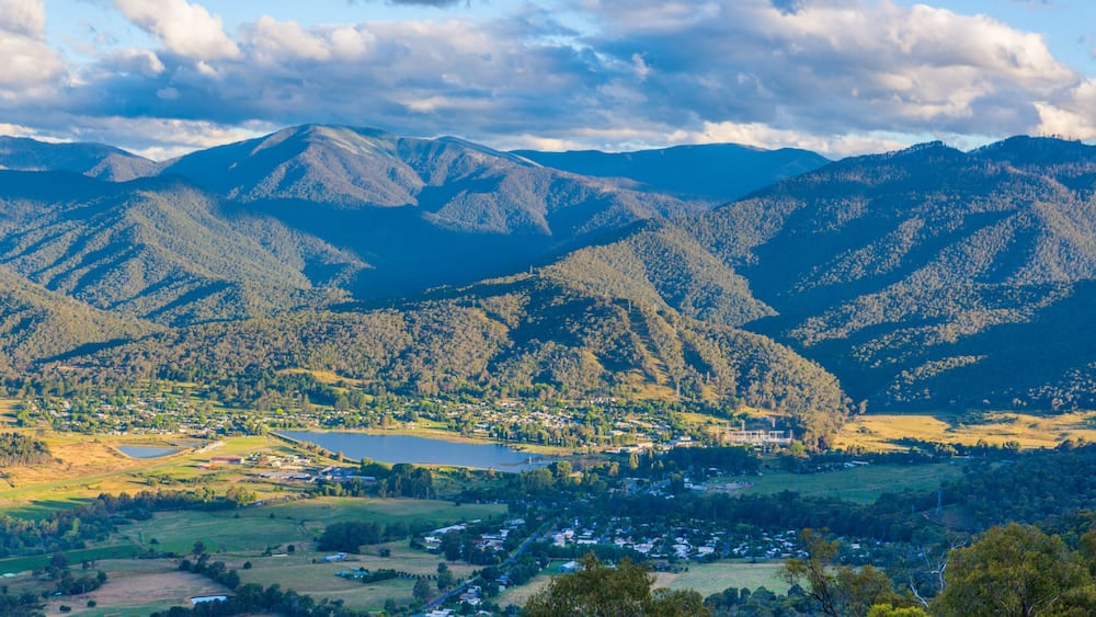 Eine Berglandschaft mit einem See und einer kleinen Stadt, eingebettet im Tal.