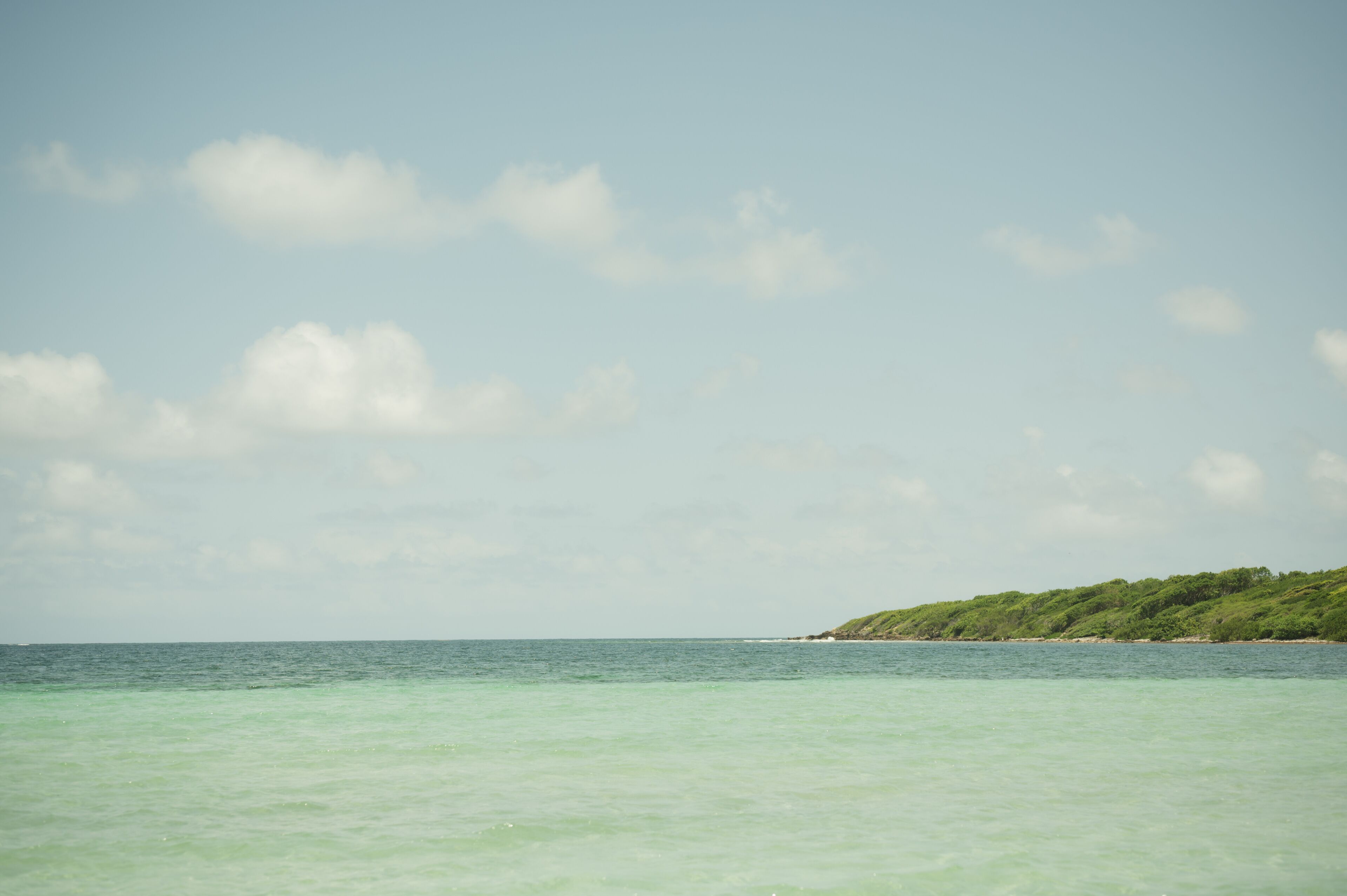 Turquoise waters and distant green coastline at Playa La Chiva