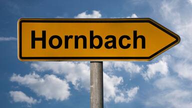 Señal direccional con la palabra 'Hornbach' indicando a la derecha.