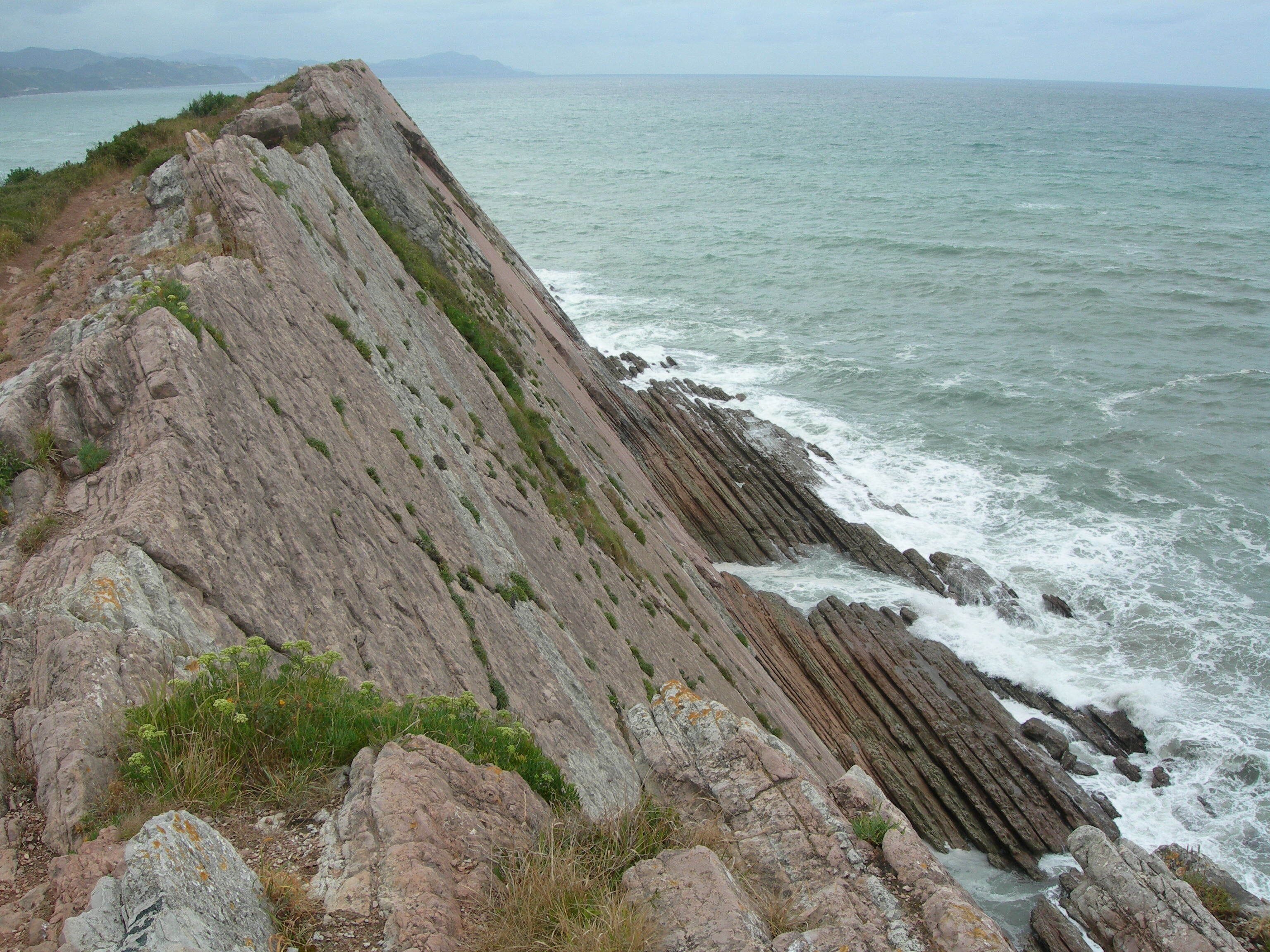 A rocky coastline with waves crashing against the shore.