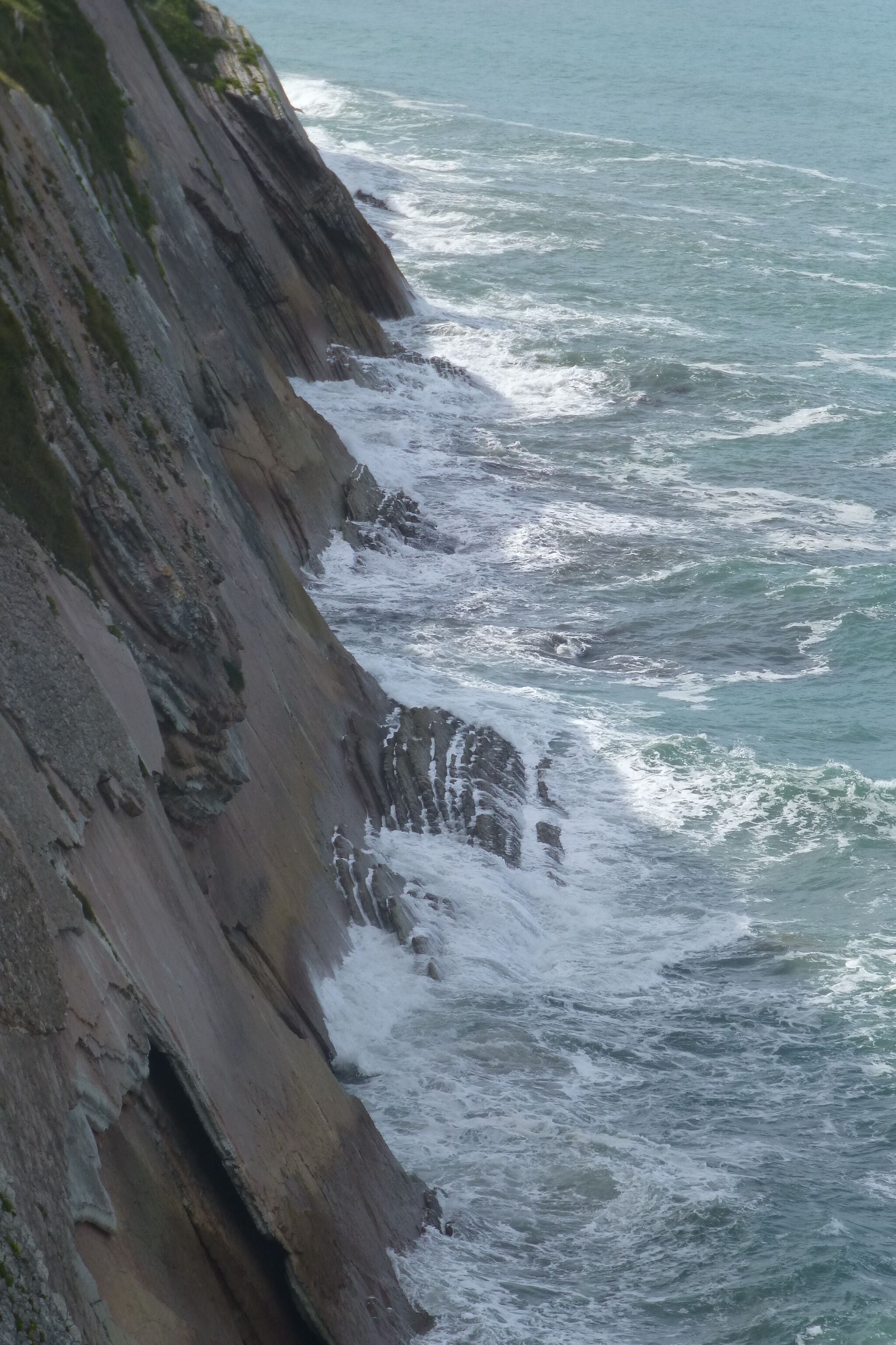 A rocky coastline with waves crashing against the shore.