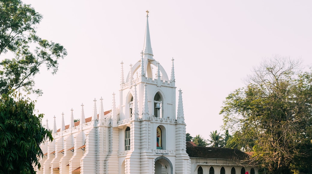 Igreja branca com uma torre alta e várias janelas em arco.