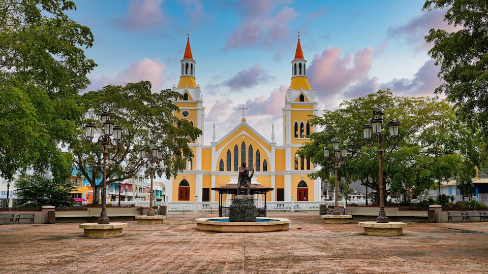 A church with two towers and a fountain in the center.