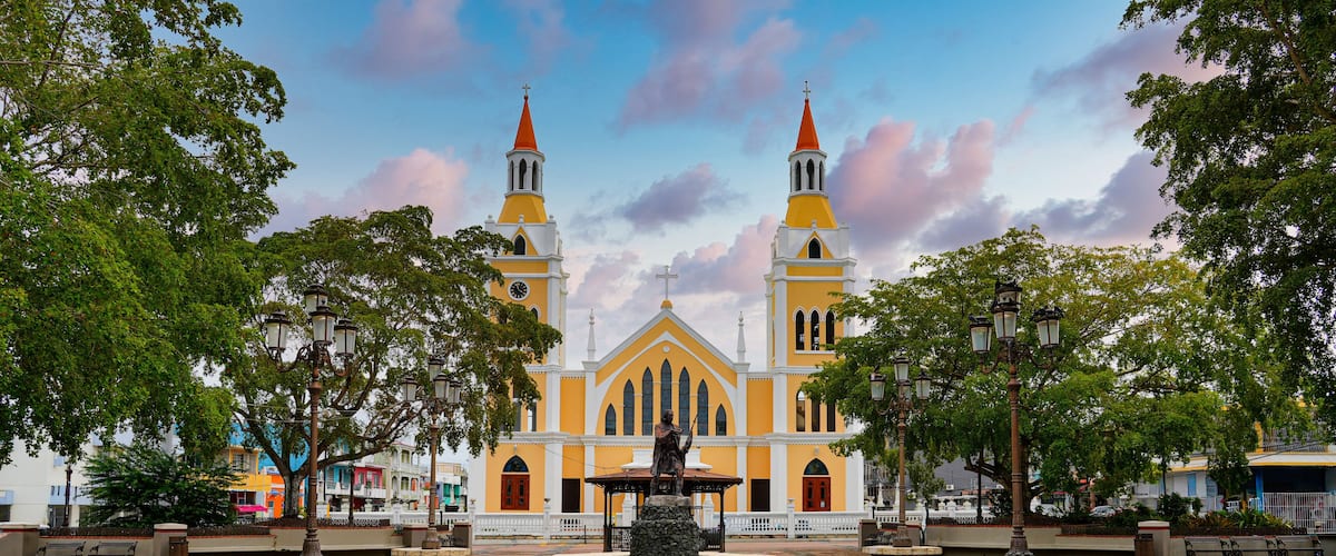 A church with two towers and a fountain in the center.
