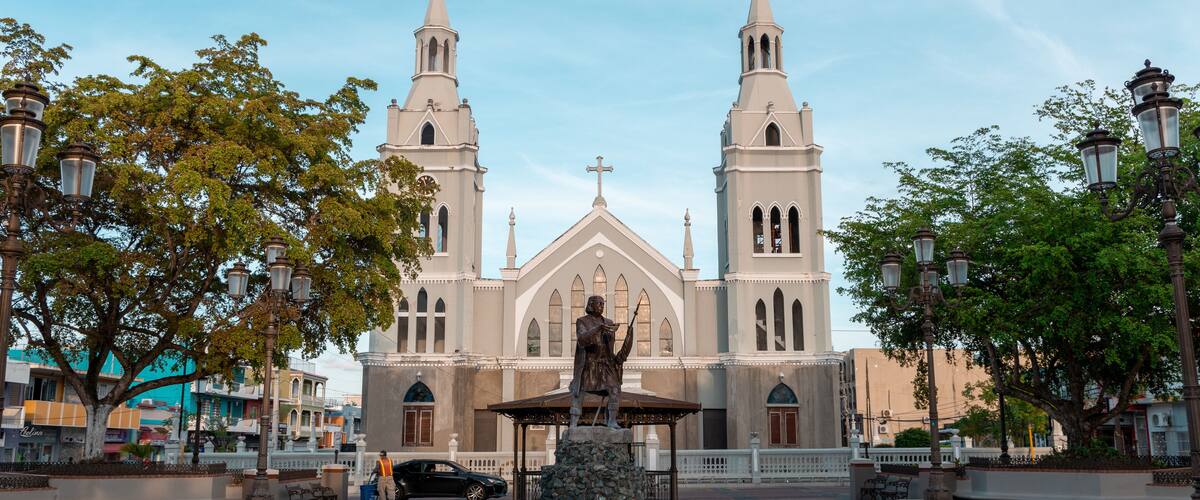 Statue of Christopher Columbus and an ancient church at the square of Aguada, Puerto Rico