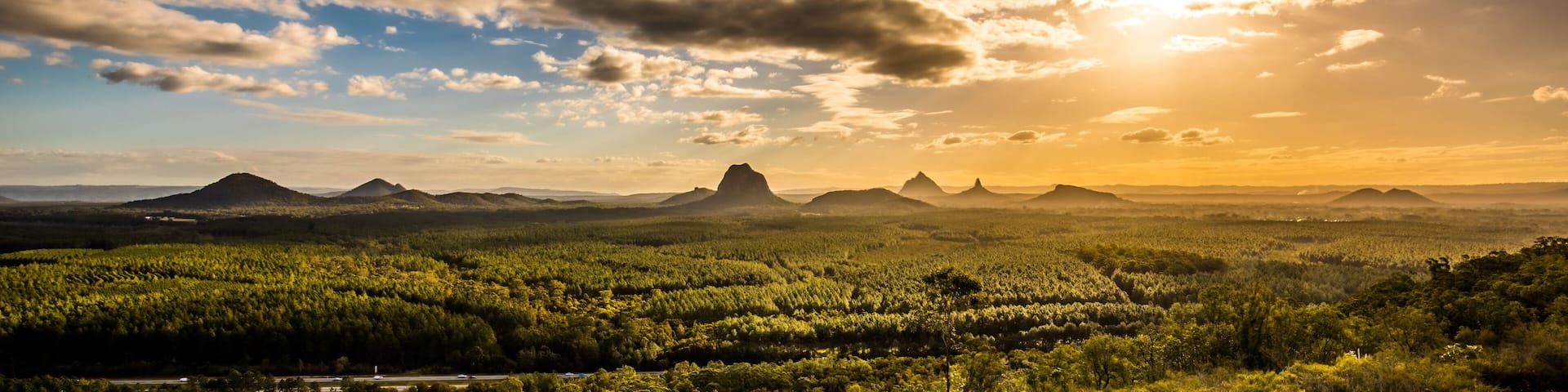 Panoramic view of Glass House Mountains at sunset visible from Wild Horse Mountain Lookout