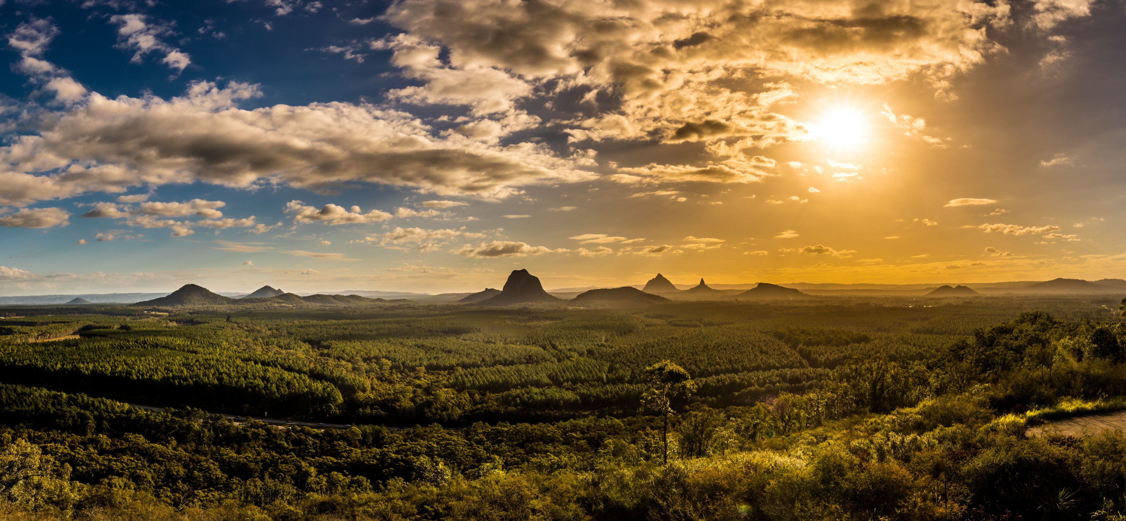 Panoramic view of Glass House Mountains at sunset visible from Wild Horse Mountain Lookout