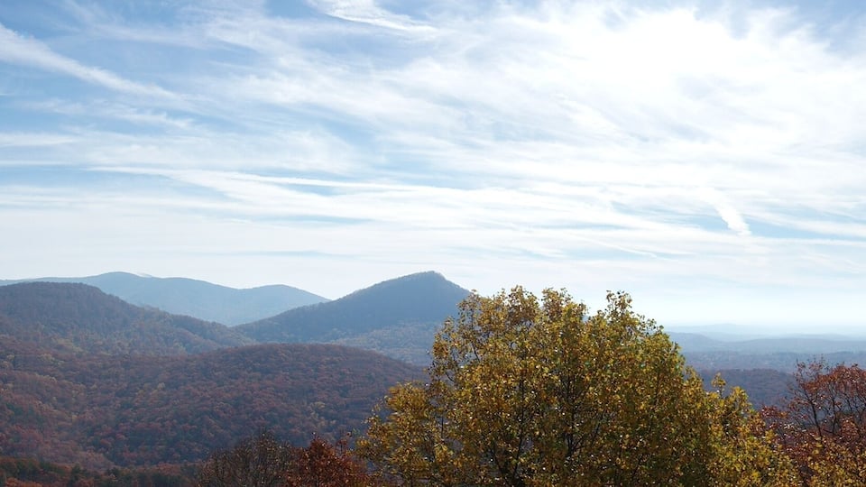 A mountainous landscape with autumn foliage and a clear sky.