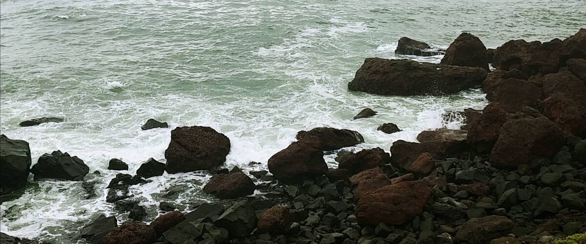 A rocky coastline with waves crashing against the rocks.