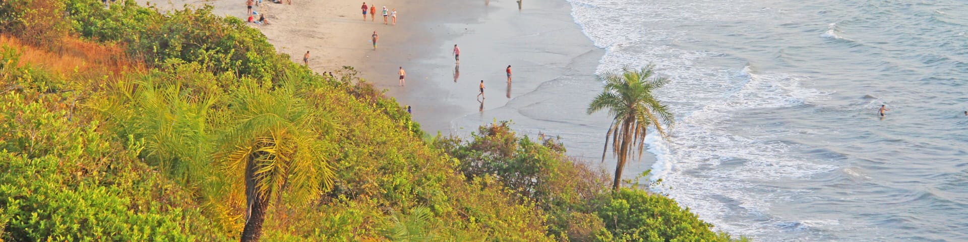 People on the beach. View from the top of the beach Vagator, India, Goa. Bay of the lagoon beach is the sea