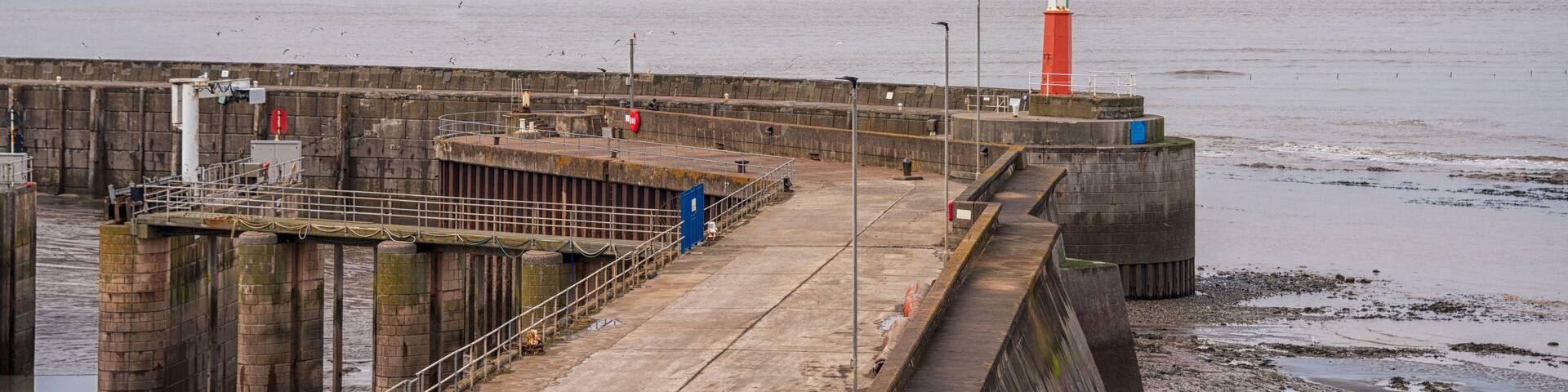 A view of a small red lighthouse on the jetty at Watchet in Somerset UK