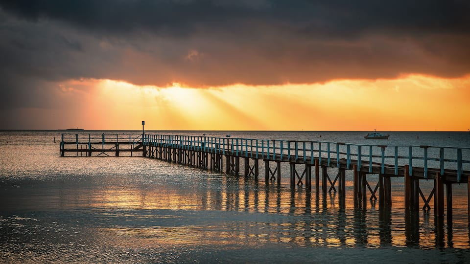 The view of the Sorrento Long Pier in Mornington Peninsula in Melbourne under the sunbeam at dawn