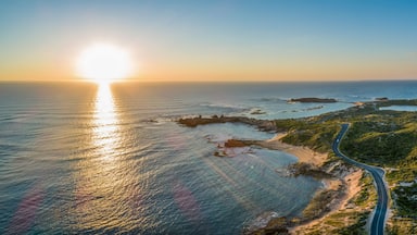 Scenic drive passing near ocean coastline and Beachport town at sunset - wide aerial panorama