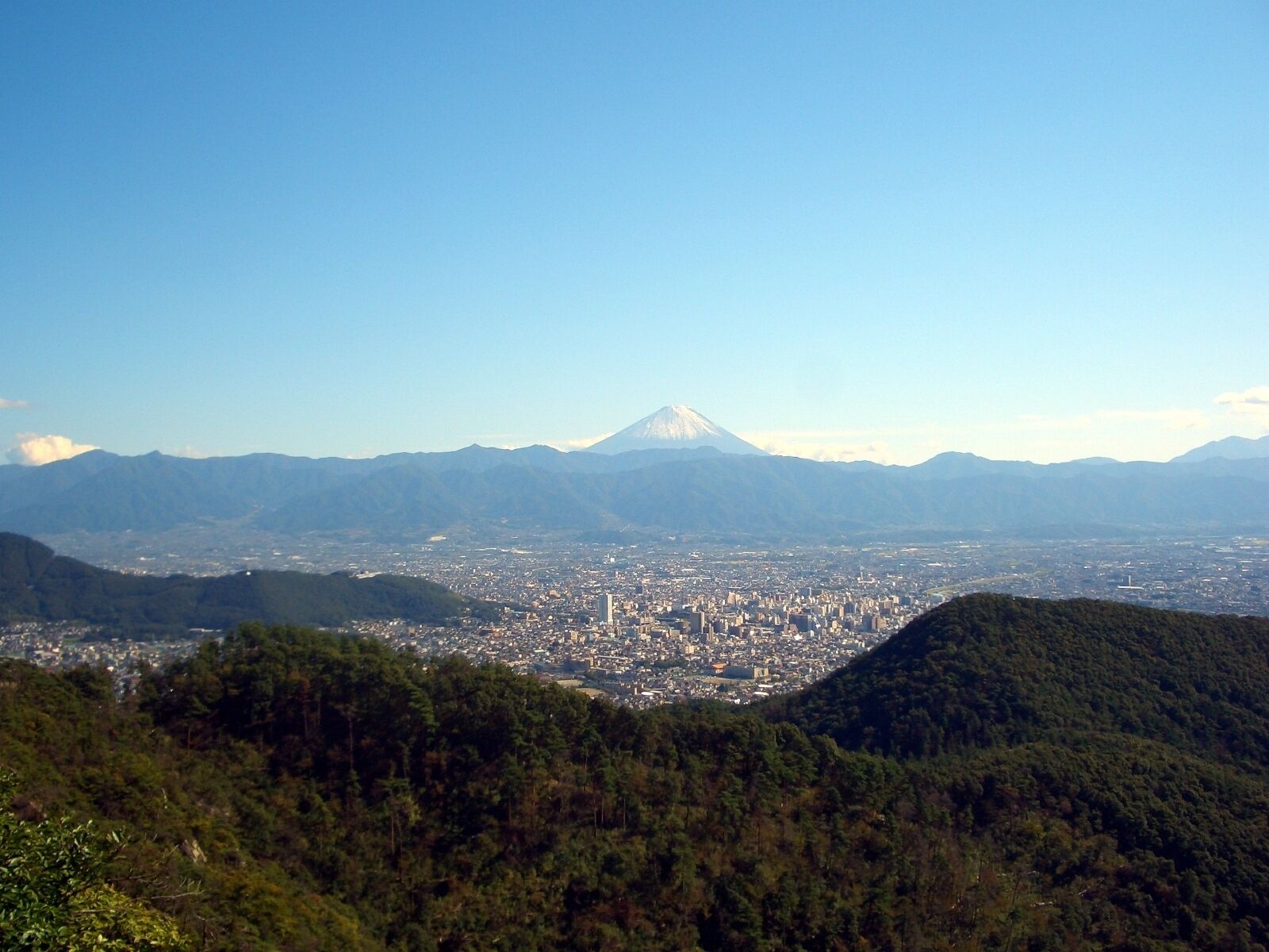 A cityscape with a prominent mountain in the background.