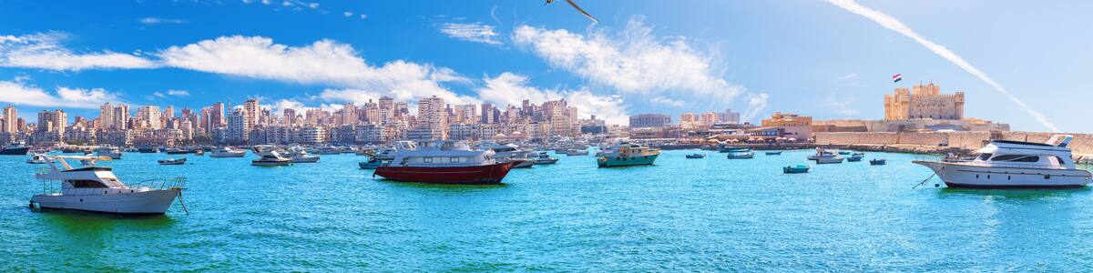 Sea panorama of Alexandria with boats, old city buildings and the citadel of Qaitbay, Egypt