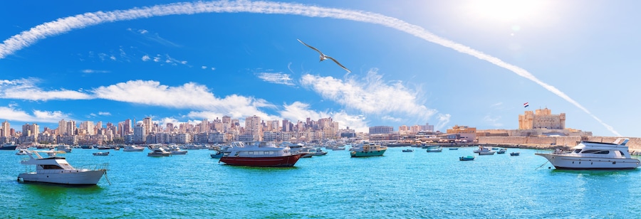 Sea panorama of Alexandria with boats, old city buildings and the citadel of Qaitbay, Egypt