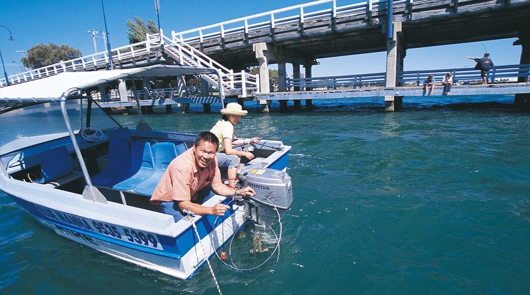Mandurah mostrando una bahía o un puerto y botes y también una pareja